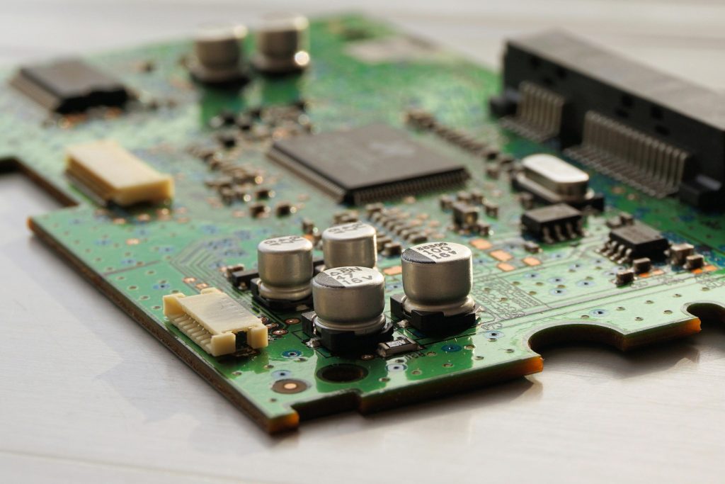 board-printed-circuit-board-computer-electronics-163125-163125 Detailed view of a green circuit board featuring capacitors and microchips.